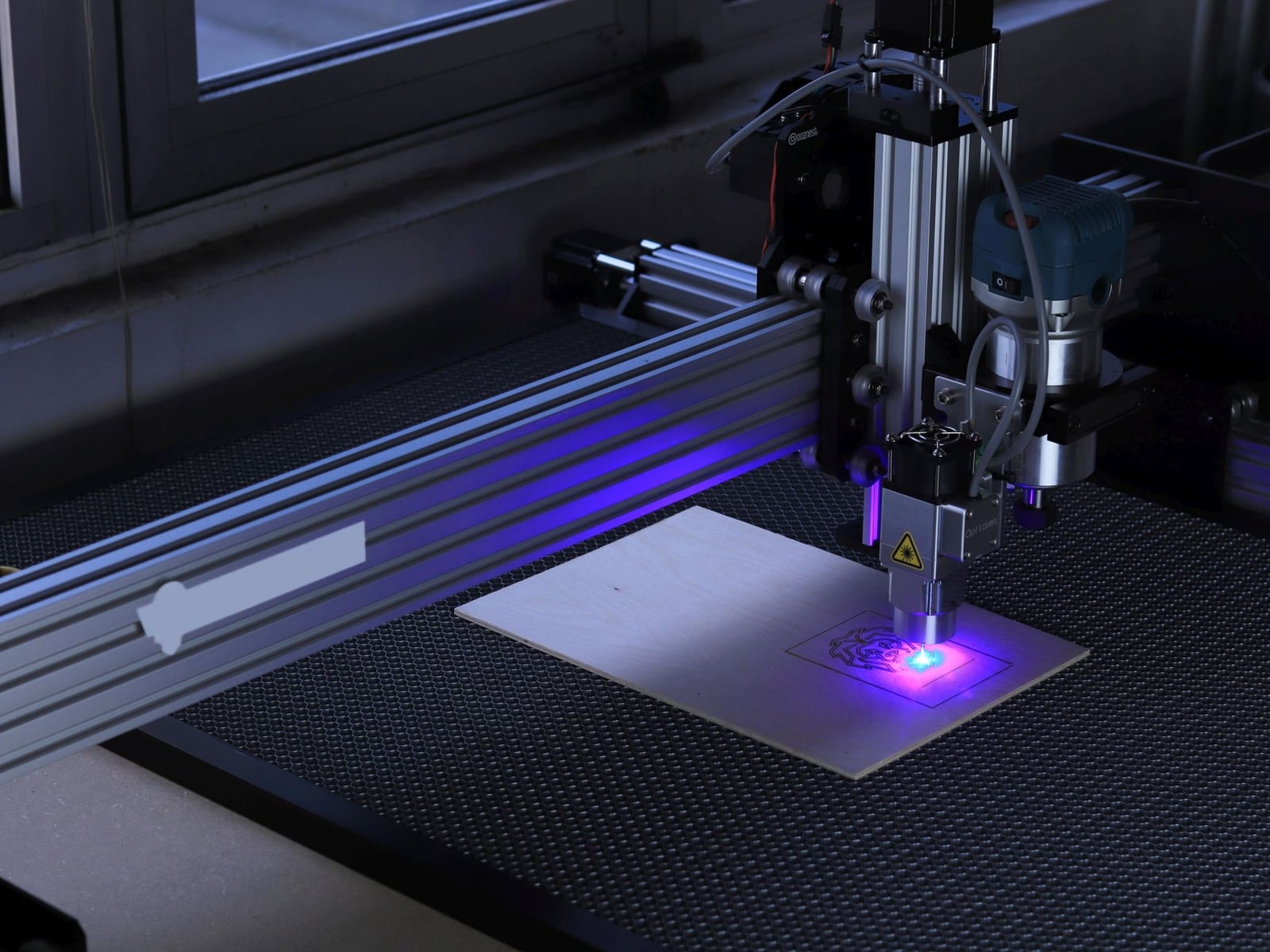 Nahaufnahme einer Lasergravur in dunklem Walnussholz mit präzisen geometrischen Mustern