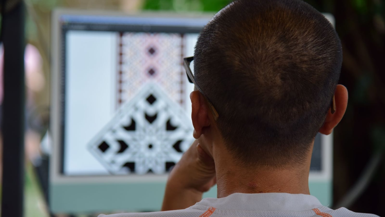 Grafikdesignerin bei der Erstellung eines Vektor-Layouts für den Laserschnitt am Monitor